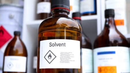 An amber glass bottle with a label saying 'Solvent' to depict solvent manufacturing